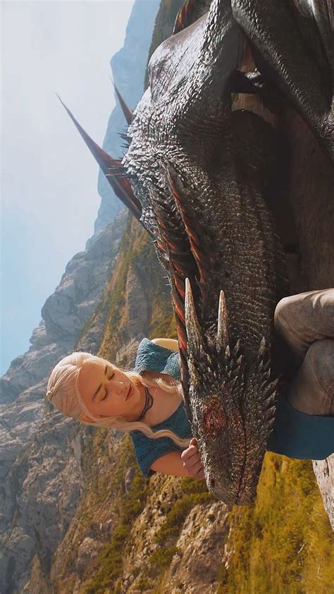 A Woman Standing Next To A Giant Dragon On The Side Of A Mountain In