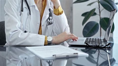 Doctor Reviewing Medical Records On Laptop Close Up Of A Healthcare