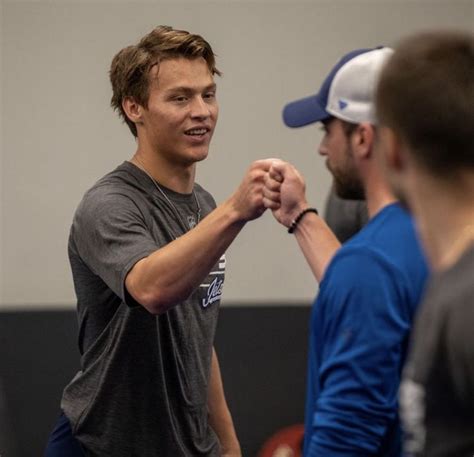 Two Men Standing Next To Each Other In A Gym