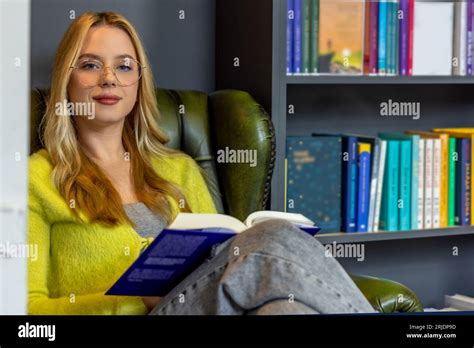 Cute Blonde Woman Reading Book In The Library Stock Photo Alamy