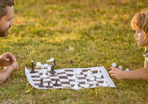 Père et fils jouant aux échecs dans le parc fête des pères bonne