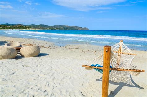 Hammock And Chairs On White Sand Beach In Porto Giunco Bay Sardinia