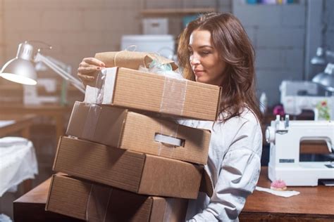 Dise Ador Sosteniendo Una Pila De Cajas De Regalo Artesanales En Taller