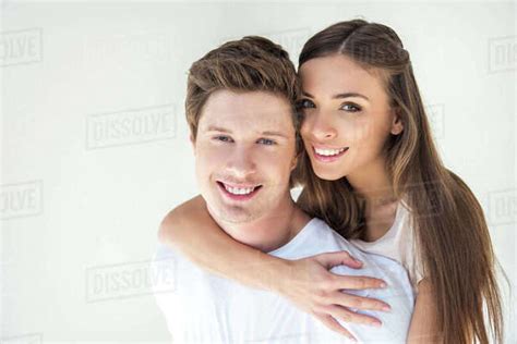 Beautiful Happy Young Couple Hugging And Smiling At Camera Isolated On