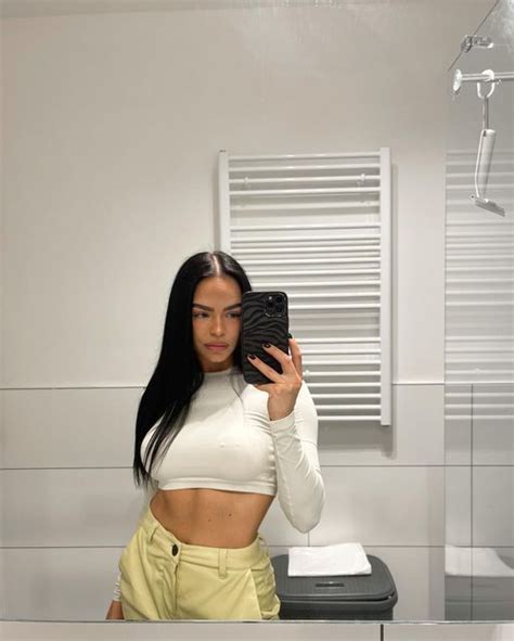 A Woman Taking A Selfie In Front Of A Mirror Wearing Yellow Pants And Crop Top