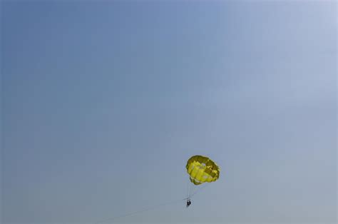 Premium Photo Two People Flying On A Parachute In The Blue Sky