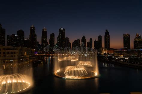 Dubai Singing Fountains at Night Lake View between Skyscrapers. City Skyline in Dusk Modern ...