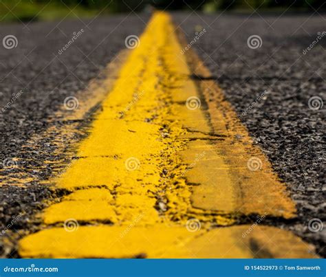 Solid Yellow Line Down A Road With Aged Pavement Stock Image Image Of