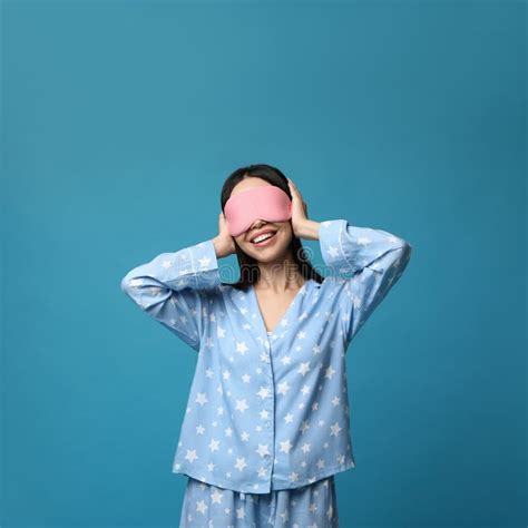 Young Woman Wearing Pajamas And Sleeping Mask On Background Bedtime