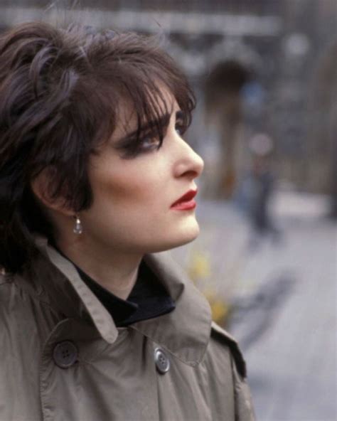 A Woman With Dark Hair And Red Lipstick Looks Off Into The Distance