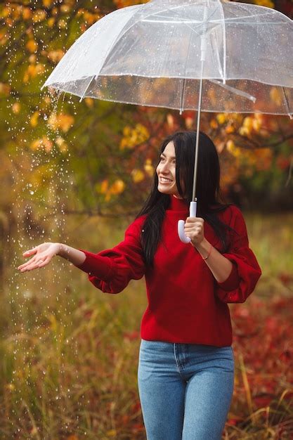 Premium Photo | Beautiful woman holding an umbrella in the rain and smiling