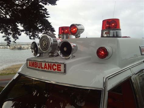 An Ambulance Is Parked By The Water With Its Lights On And Emergency