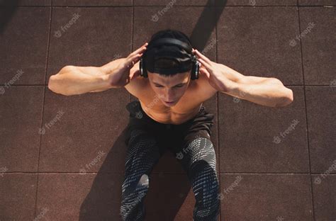 Premium Photo Image Of Young Caucasian Man Doing Situps And Listening The Music From His