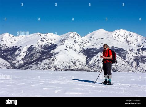 Female In Red With Snowshoes On Snow Slope Plateau De Beille French