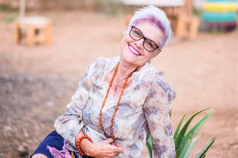 Premium Photo Portrait Of Smiling Mature Woman Sitting Outdoors