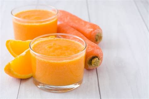 Premium Photo Orange Apple And Carrots Smoothie On White Wooden Table