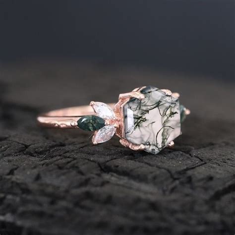 A Green And White Stone Ring On Top Of A Piece Of Wood