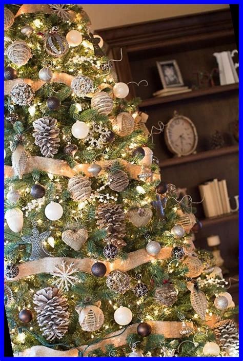 A Christmas Tree Decorated With Silver And White Baubles Pineconis