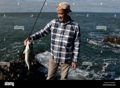 Sea Bass Fisherman With Rod And Catch Stock Photo Alamy