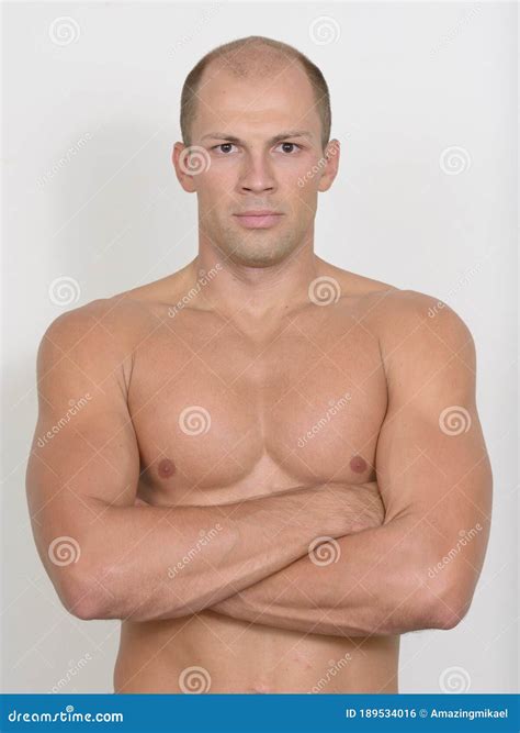 Young Handsome Muscular Bald Man With Arms Crossed Shirtless Stock