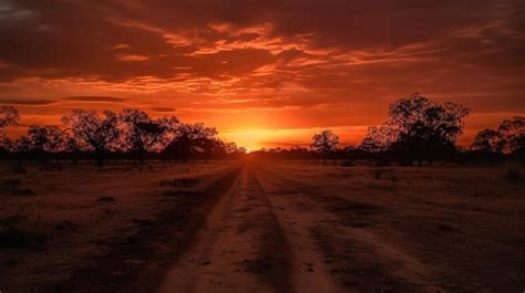 Um pôr do sol uma estrada em primeiro plano e um céu vermelho o