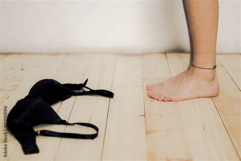 Bare Feet And Black Bra Lying On Natural Hardwood Floor Because A Woman