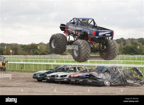 monster truck jumping crushed cars in a race Stock Photo - Alamy