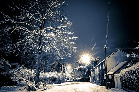 Snowy street scene at night, Hale Barns, Cheshire, UK Photograph by ...