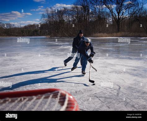 Boys Playing Ice Hockey On A Frozen Pond Stock Photo Alamy