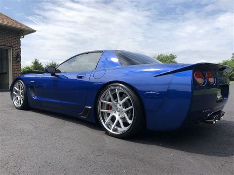 a blue sports car parked in front of a garage