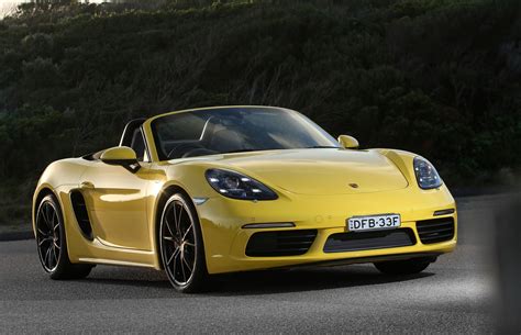 the yellow sports car is driving down the road