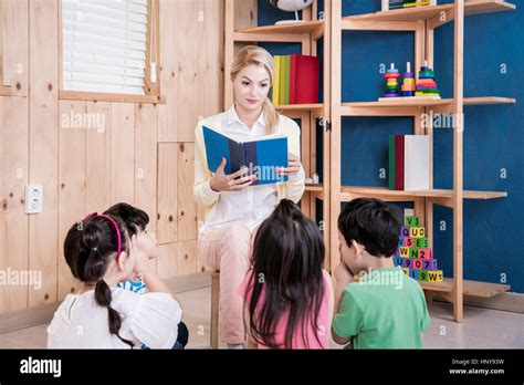 Foreign Teacher Reading Book To Kindergarten Children Stock Photo Alamy