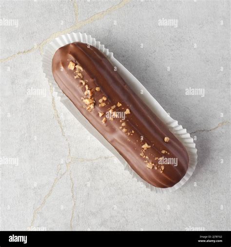 Traditional French Dessert Eclair With Custard And Milk Chocolate Glaze On A Stone Background