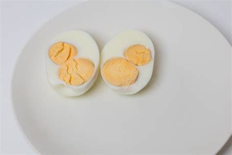 Half Chicken Egg On A White Plate An Egg Has Two Yolks Stock Photo