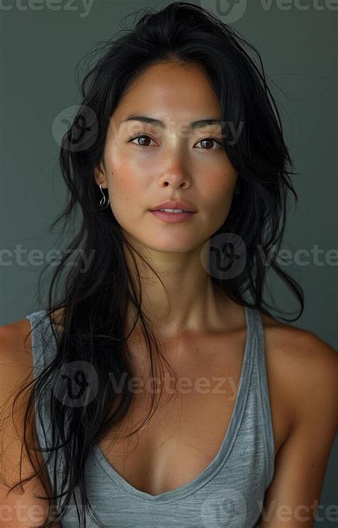 Asian Woman With Long Black Hair Wearing A Grey Tank Top Posing For