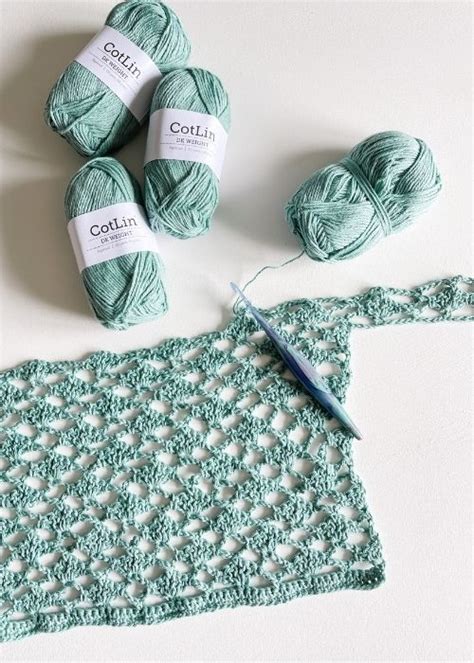 Several Balls Of Yarn Sitting On Top Of A Table Next To A Crochet Doily