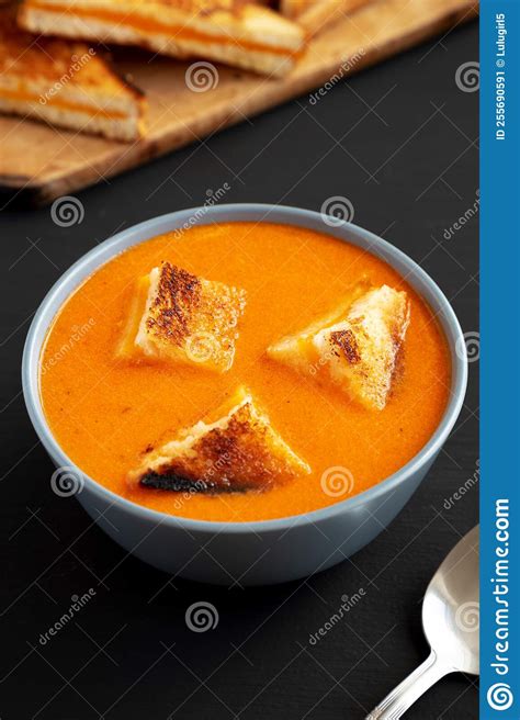 Homemade Tomato Soup With Grilled Cheese Croutons On A Black Background