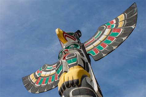 Bright Colorful Totem Pole Spreading Wings Against Sky Stock Photo