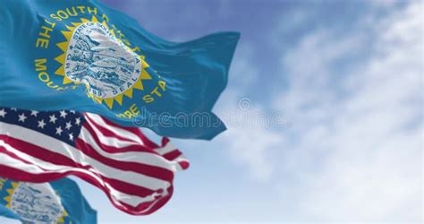 The South Dakota State Flag Waving Along With The National Flag Of The