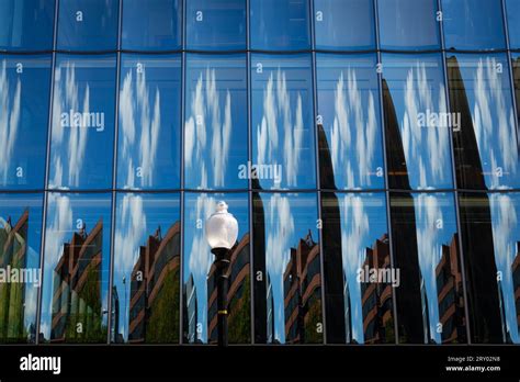 Reflections Of Clouds And Buildings On The Glass Facade Of An Office