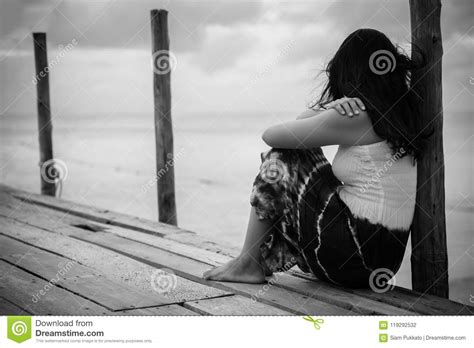 Black And White Of Sad And Lonely Woman Sitting Alone Stock Photo