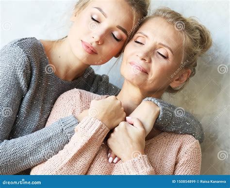 Beautiful Senior Mom And Her Adult Daughter Are Hugging Looking At