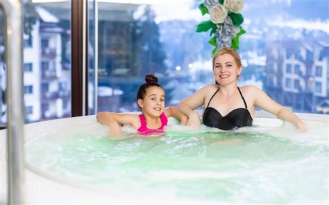 Madre e hija relajándose en jacuzzi privado gente sonriendo concepto