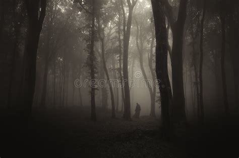 Silhouette Of Man In Dark Haunted Scary Forest On Halloween Night Stock