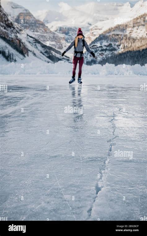 Young Woman Skating on Frozen Lake Towards Ice Crack Stock Photo - Alamy