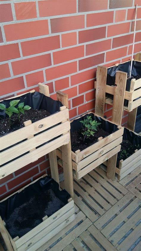 Two Wooden Planters Sitting Next To Each Other On Top Of A Brick Wall