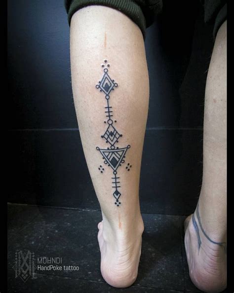 A Womans Leg With A Tattoo Design On The Lower Part Of Her Legs