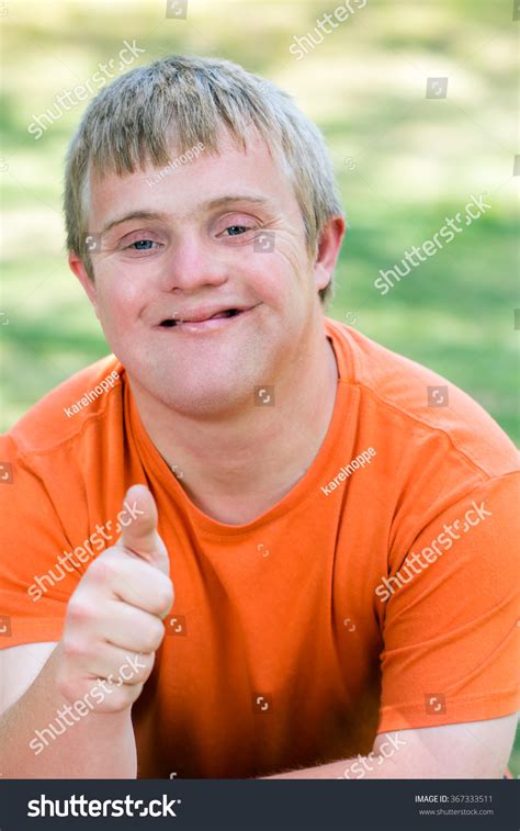 Close Up Portrait Of Friendly Young Man With Down Syndrome In Orange T ...