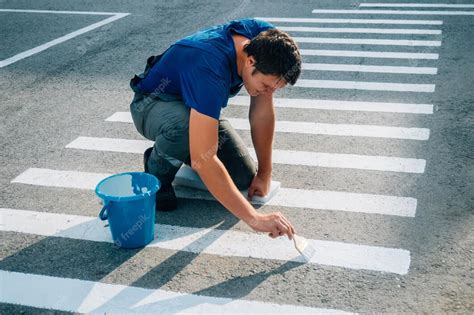 Premium Photo Road Service Worker Paints Striped Pedestrian Crossing