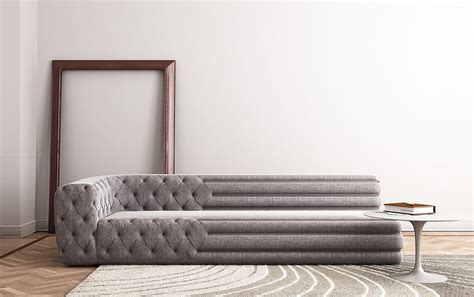 a gray couch sitting on top of a wooden floor next to a white table and chair